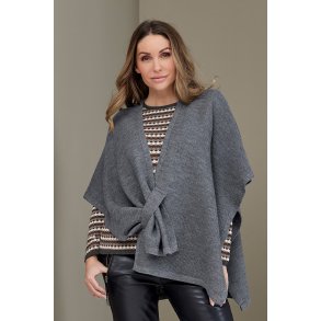 Kvinde ifrt ensfarvet poncho i meleret glatstrik med smart lukning