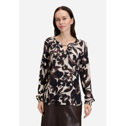 Smilende model med den l�se brune bluse, der viser de behagelige raglan�rmer.