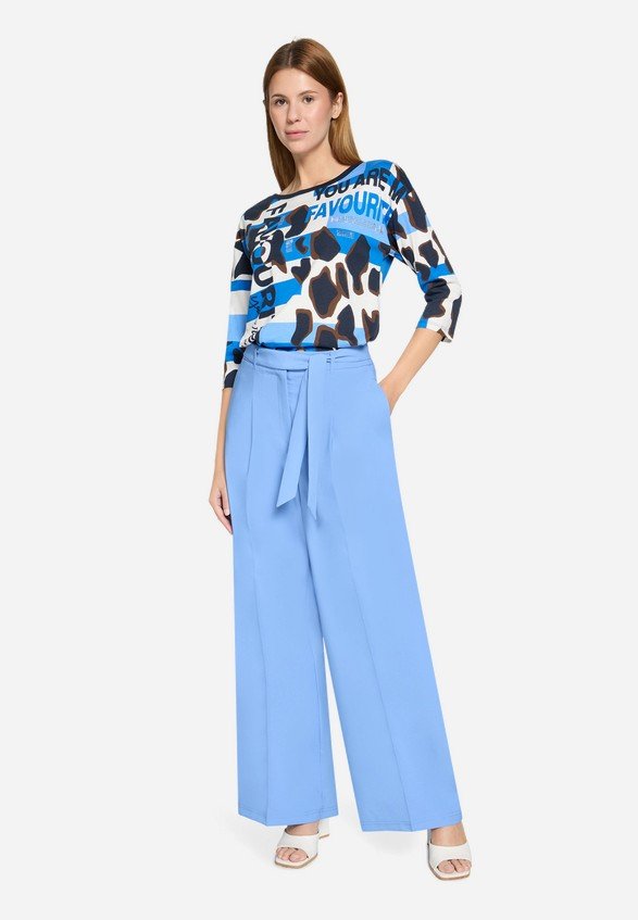 Model i lysebl� h�jtaljede bukser med brede ben og flotte l�g foran.