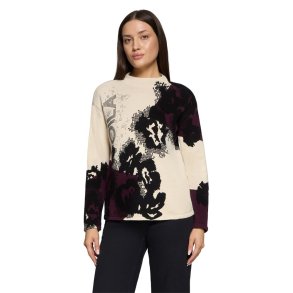 Model i creme og bordeaux m�nstret strikbluse med h�j krave og lige pasform. Vist forfra