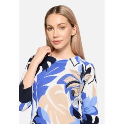 N�rbillede af blomsterm�nsteret og de sm� glitrende detaljer p� den lysebl� strikbluse.