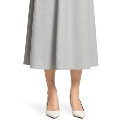 N�rbillede af den lysegr� nederdels linning, b�ltestropper og de fine syninger.