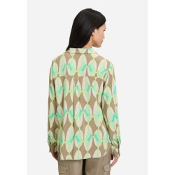 Ryggen af en khaki og gr�nm�nstret bluse p� en model, der viser det bl�de fald og pasform