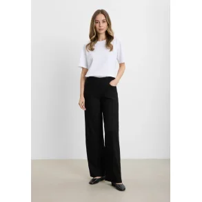 Model ifrt sorte Donna Loose bukser fra Laurie sammen med en lys bluse – moderne look til hverdagsbrug