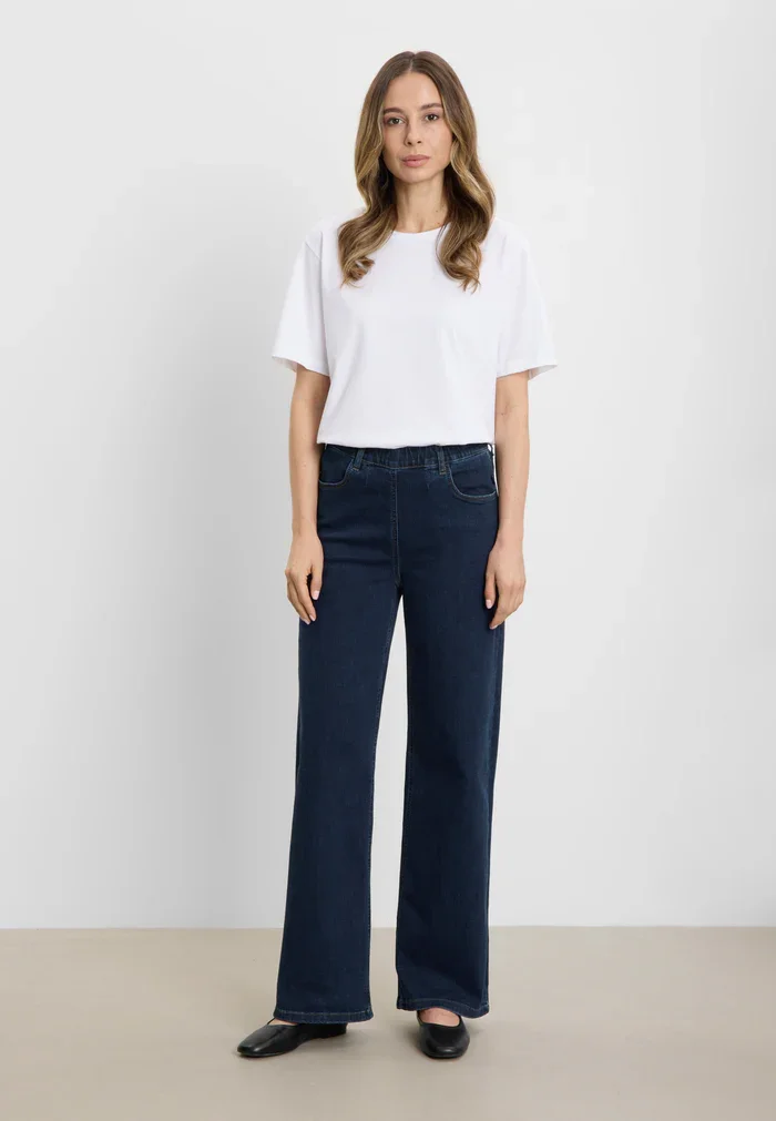 Model ifrt Donna Loose cowboybukser fra Laurie med brede ben, stylet med tee set forfra 