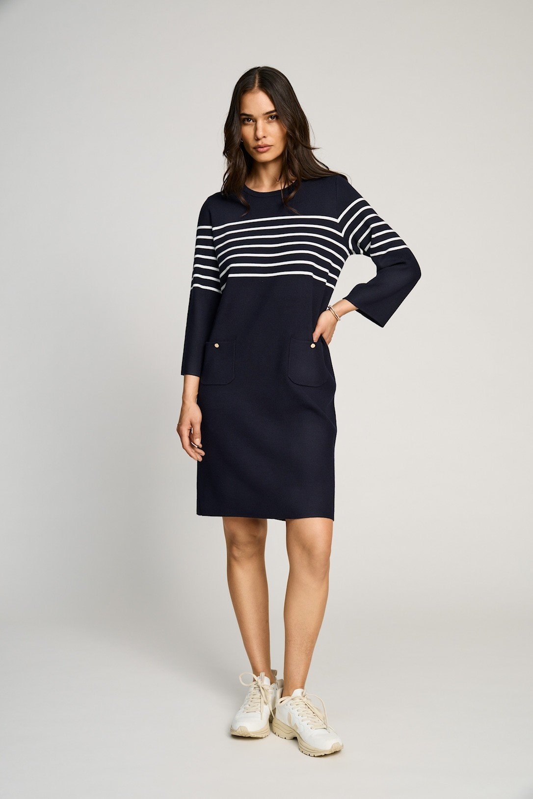 Model i en flot navy strikkjole fra Micha med hvide striber ved brystet og 3/4 �rmer.